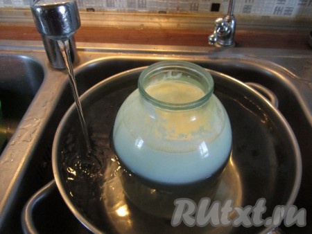 Ставим в кастрюлю на подставку банку с простоквашей и аккуратно наливаем по плечики горячей воды.