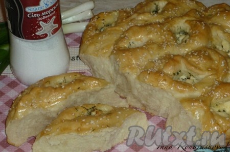 Мягкий, ароматный и вкусный пирог из дрожжевого теста с начинкой из брынзы и зелени готов. На фото видно, как легко он делится на порции.