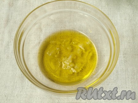 В небольшую ёмкость влить оливковое масло и выдавить чеснок. 
