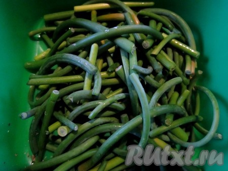 Чесночные стрелки помоем и нарежем на кусочки.