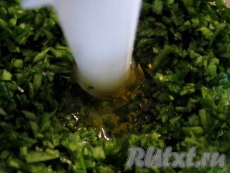 В большой стакан блендера кладём чесночные стрелки, листья базилика и заливаем оливковым маслом. Измельчаем.