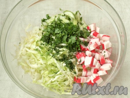 Соединить в салатнике крабовые палочки, капусту и огурцы. Добавить измельчённую зелень.