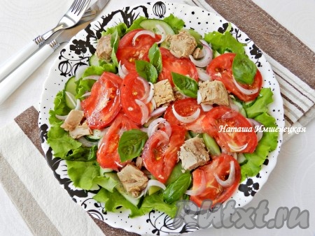 Выложить помидоры. Из банки с консервированным тунцом слить жидкость. Кусочки тунца и листья базилика разложить следующим слоем. Приготовить заправку, для этого смешать оливковое масло, лимонный сок, чёрный молотый перец, добавить по вкусу соль, тщательно перемешать. Полить салат равномерно сверху заправкой. Вкусный, сочный, яркий салат с консервированным тунцом, помидорами и листьями салата сразу подавать к столу.