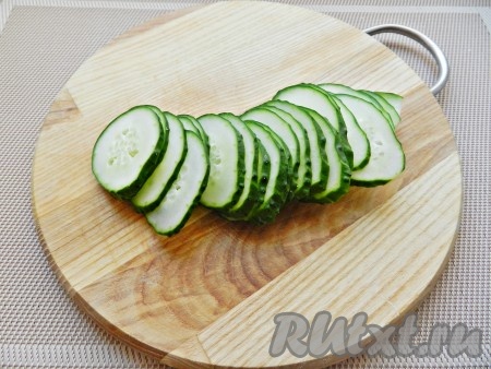 Нарезать огурец на тонкие кружочки.