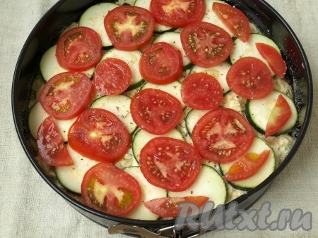 Нарезать тонкими кружками оставшийся кабачок. Кружочками нарезать помидоры. Выложить на поверхность кабачки, посолить и поперчить, затем помидоры и также их посолить и поперчить.