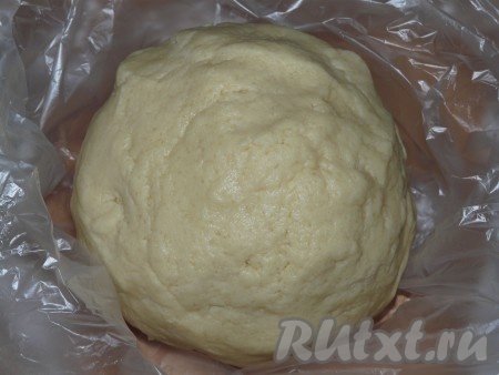 Муки, в зависимости от влажности творога, может потребоваться немного больше или меньше, ориентируйтесь на консистенцию теста. Оно должно получиться мягким, эластичным, не липнущим к рукам. Скатать творожное тесто в шар, завернуть в пищевую плёнку и убрать в холодильник на 30-40 минут.