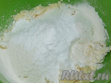 Затем всыпать разрыхлитель и начать частями добавлять муку, тщательно вмешивая её в творожное тесто.
