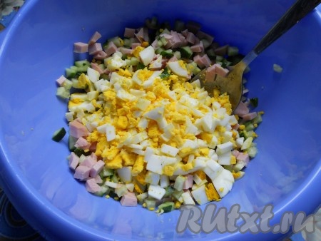 Яйца отварить вкрутую, остудить, очистить и мелко нарезать. Добавить к колбасе и огурцам.