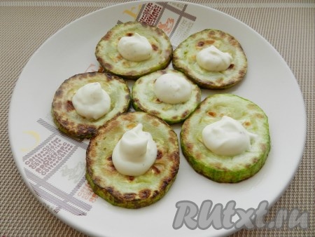 На кружочки кабачка выложить немного соуса.