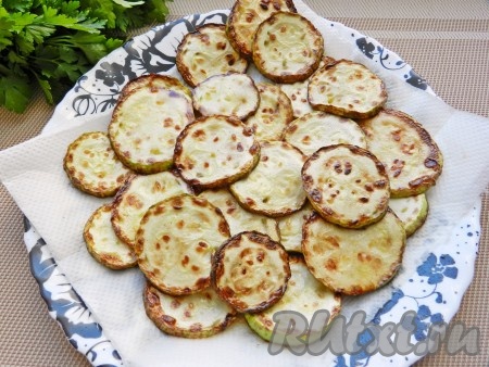 Обжаренные кабачки выкладывать на бумажное полотенце, чтобы удалить излишки масла.