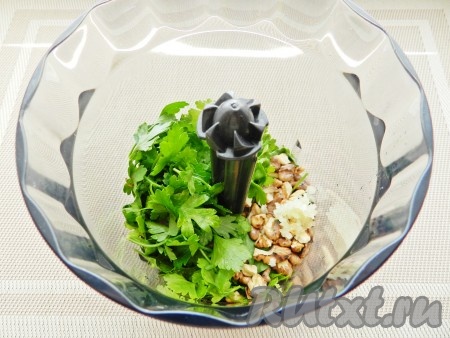 Сложить петрушку, орехи и чеснок в чашу блендера и измельчить.