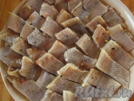 Сельдь чистим, если используем целую. Я честно признаюсь в стойкой нелюбви к чистке селёдки, из-за чего я часто использую уже готовое филе. Рыбу режем на кусочки и выкладываем ровным слоем на блюдо или в селёдочницу.
