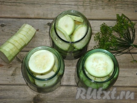 В предварительно вымытые литровые банки на дно выложить зелень, а поверх зелени - подготовленные кабачки.&nbsp;
