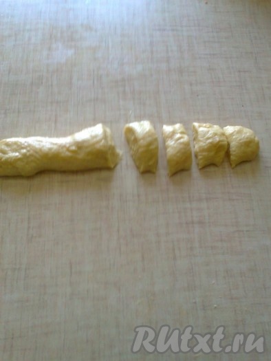 Тесто подошло, смазываем руки маслом и делим тесто на 4 части. Мука в этом рецепте больше не нужна. Работаем только с маслом. Когда руки в масле, с тестом удобно работать. Из каждой части скатываем колбаску, делим на 8 частей и скатываем шарики, диаметром не более 5 см.
