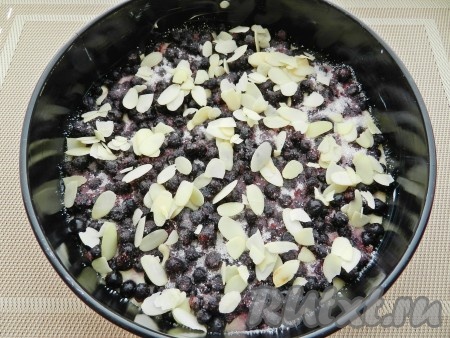 Свежую чернику нужно заранее промыть водой, обсушить. Замороженные ягоды, если на них немного льда, можно не размораживать. Поверх теста равномерно разложить подготовленную чернику, посыпать 2 столовыми ложками сахара. Я дополнительно ещё присыпала хлопьями миндаля, но это по желанию.