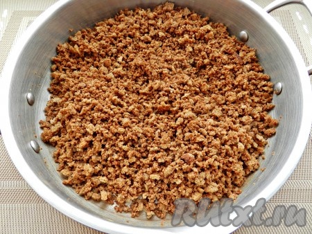 Поставить на средний огонь и прогревать в течение 15-20 минут, постоянно помешивая, и еще больше измельчая крошки. Затем снять с огня и полностью остудить.