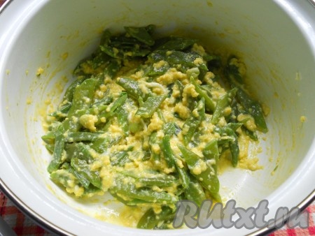 Аккуратно, небольшими порциями влить яйца в кастрюлю с фасолью, тщательно все перемешивая. Когда яйца свернутся, огонь выключить.