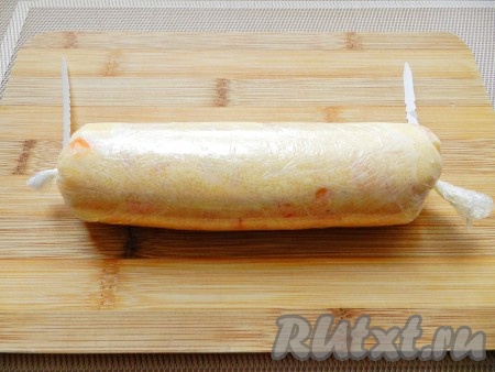 На разделочной доске расстелить пищевую пленку, выложить мягкое масло и скрутить пленку, плотно закрепив концы. В таком виде убрать икорное масло в морозилку для застывания.