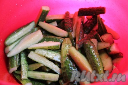 Огурцы вымыть, отрезать "кончики" с двух сторон. Разрезать огурчики на 4 части или больше, если огурцы большие. Огурцы выложить в глубокую миску. К огурцам добавить уксус, масло, сахар, соль, чёрный молотый перец и пропущенный через пресс чеснок, перемешать и оставить на 1,5 часа, периодически перемешивая.