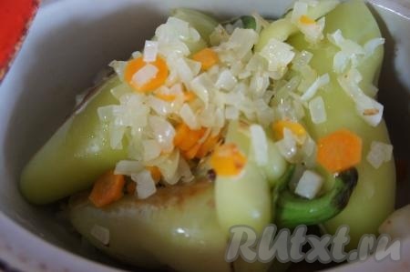 Обжаренные фаршированные перцы переложить в кастрюлю. Накрыть каждый перчик "крышечкой", выложить ранее обжаренные лук и морковь.