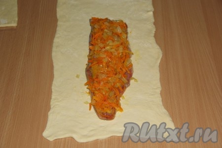 Тесто разрезать на две части. Каждый пласт теста немного раскатать. Выложить филе рыбы на тесто, сверху выложить овощи и разровнять.