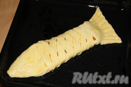 Из остатка теста сформировать хвост. Аккуратно переложить пирог на противень смазанный растительным маслом. Смазать верх пирога взбитым яичным желтком.