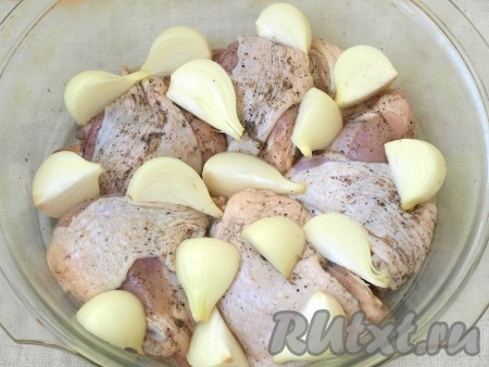 Лук разрезать на 4 части и выложить между кусками курицы.