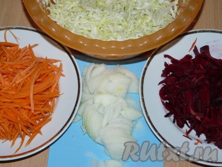 Капусту тонко нашинковать, помять руками, чтобы она дала сок. Затем добавить к капусте сахар, соль, уксус, хорошо перемешать. Лук порезать полукольцами. Натереть морковь и свёклу на тёрке для корейской моркови.
