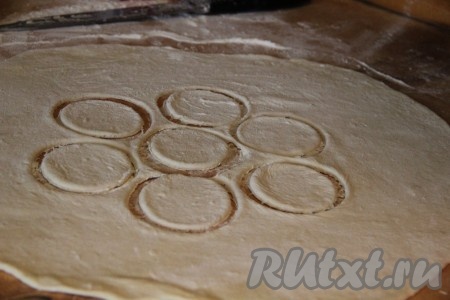 Каждую часть теста на присыпанной мукой поверхности раскатать в пласт толщиной 2-3 миллиметра. С помощью стакана выдавить кружочки из теста.