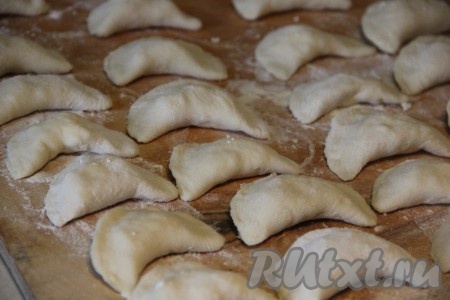 Защипнуть противоположные края каждого кружка, формируя вареник. Постепенно сформировать все вареники. Если вареников получается больше, чем вы можете скушать за раз, тогда часть вареников можно отварить, а оставшиеся вареники выложить в один слой на доску, присыпанную мукой, и отправить в морозилку, после замораживания их можно сложить в пакет и хранить в морозилке, а затем в нужный момент отварить их, помещая в замороженном виде в кипящую воду. 