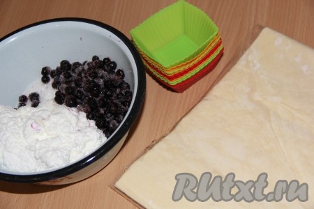 Тесто предварительно разморозить при комнатной температуре. Для этой выпечки можно взять как бездрожжевое слоёное тесто, так и дрожжевое. Смородина подойдёт как свежая, так и замороженная. Свежие ягоды нужно промыть водой и обсушить, разложив их на бумажном полотенце. Замороженные ягоды, если на них нет большого количества льда, можно не размораживать. Творог, подготовленную смородину и сахар выложить в глубокую миску, перемешать и начинка для слоек готова.