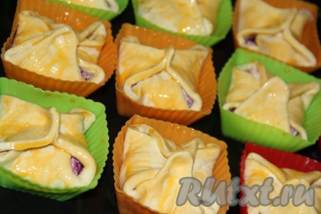 В небольшой ёмкости вилкой взбить яичный желток. С помощью силиконовой кисти смазать поверхность слоек взбитым желтком.&nbsp;