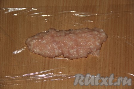 Пищевую плёнку нарезать на прямоугольники. Выложить на середину пищевой плёнки 2 столовых ложки фарша.