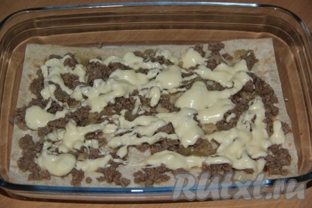 В жаропрочную форму выложить лист лаваша (лаваш преварительно нарезать под размеры формы). Выложить часть фарша, разровнять. Затем полить соусом. 