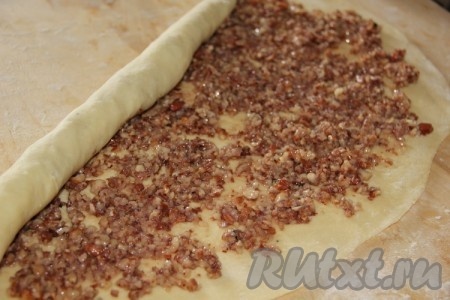 Тесто разделить на 2 части. Каждую часть теста на присыпанной мукой поверхности раскатать в тонкий пласт размером приблизительно 30 сантиметров на 40 сантиметров. На одну часть теста, немного отступив от краёв, намазать ореховую начинку, на другую - маковую. Скатать каждый пласт теста в трубочку.