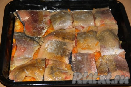 Филе горбуши (шкуру я сняла, но это необязательно) нарезать на порционные кусочки, посолить и поперчить. На противень равномерно выложить лук и морковь, затем разложить кусочки горбуши.
