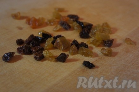Изюм выкладываем в небольшую ёмкость, заливаем кипятком, оставляем на 5 минут, затем перекладываем изюм на бумажное (или тканевое) полотенце, чтобы он обсох. Если изюм крупный (как в моём случае), необходимо его измельчить.