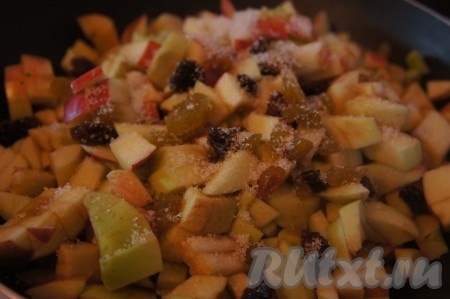 На сковороде разогреваем растительное масло, выкладываем яблоки и изюм. Присыпаем яблоки с изюмом сахаром, добавляем ванилин и корицу, перемешиваем и тушим на среднем огне 5-7 минут, иногда помешивая (яблоки должны стать достаточно мягкими).