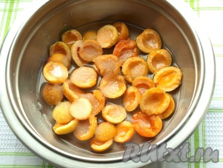 Для приготовления заливки нужно абрикосы вымыть, разделить на половинки, удаляя косточки. Переложить половинки абрикосов в кастрюлю, добавить сахар, влить воду, дать закипеть и варить на небольшом огне 2-3 минуты (до растворения сахара). Убрать с огня дать немного остыть.