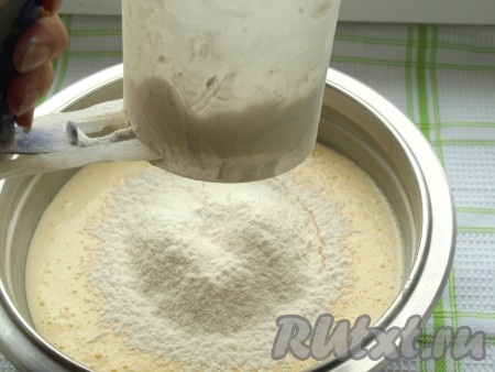 Перелить яичную массу в миску, частями начать добавлять просеянную муку, каждый раз полностью вмешивая движениями лопатки снизу вверх.