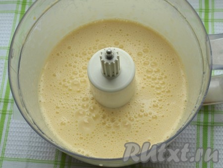 Приготовление торта начнём с выпекания бисквита. В чашу комбайна (или в чашу, в которой будет удобно взбивать миксером) разбить яйца. Начать взбивать яйца в комбайне (или миксером), постепенно добавляя сахар. Взбивать яйца с сахаром нужно в течение 6-7 минут (до увеличения яичной массы в объёме в 2 раза).