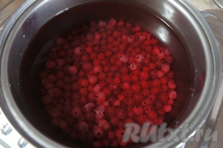 Ягоды красной смородины выкладываем в кастрюлю, заливаем 1 литром воды и ставим на сильный огонь.