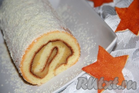 Посыпать сахарной пудрой очень вкусный бисквитный рулет с заварным кремом.
