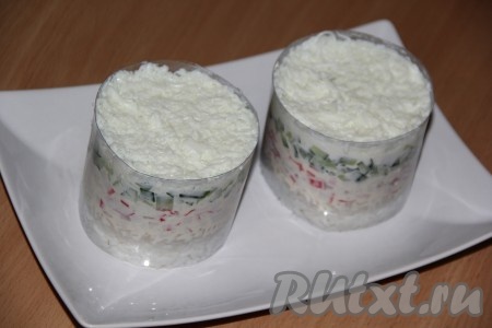 Смазать огурцы плавленным сыром. Отделить белки от желтков. Белки натереть на мелкой тёрке, немного утрамбовать, смазать сыром.&nbsp;