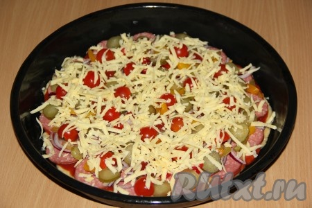 Посыпать пиццу сыром, натёртым на крупной тёрке, и поставить в разогретую духовку, выпекать при температуре 180 градусов, примерно, 15-20 минут.