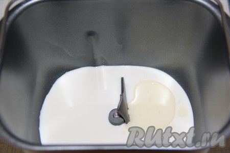 В ведёрко хлебопечки влить тёплое молоко, растительное масло.
