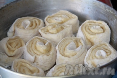 Смазанный пласт туго скатать в рулет и нарезать острым ножом на куски толщиной 5 сантиметров. В форму для запекания, смазанную маслом, выложить получившиеся рулетики на расстоянии 1 сантиметр друг от друга.