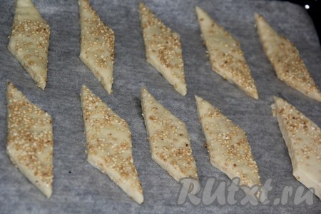 Нарезать получившуюся слоёную заготовку ножом на ромбовидное (или квадратное, или любой другой формы) печенье, переложить на противень, застеленный&nbsp; пергаментом, на небольшом расстоянии друг от друга и поставить в заранее разогретую духовку. Выпекать печенье при температуре 180 градусов примерно 25 минут (до лёгкого зарумянивания, выпечка получится светлой).
