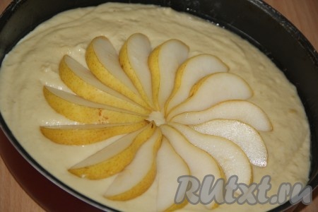 Духовку заранее разогреть до 180 градусов. Выложить тесто в форму для выпечки, смазанную растительным маслом. Груши нарезать, удалить семена. Выложить кусочки груши на тесто в виде цветка, как на фото.