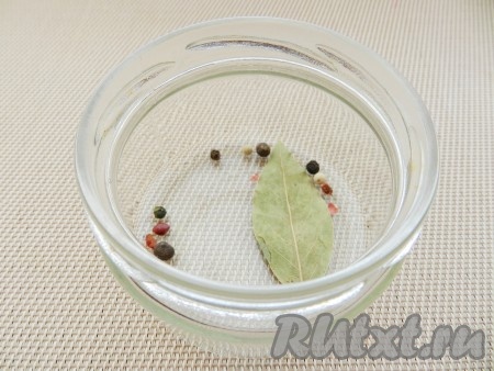 В небольшую баночку выложить лавровый лист, горошины душистого и чёрного перцев.